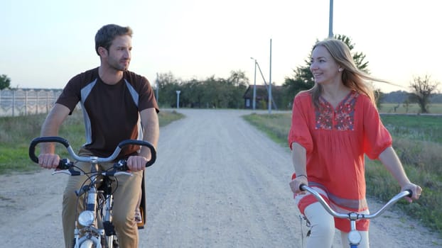 A loving couple on bicycles in the evening