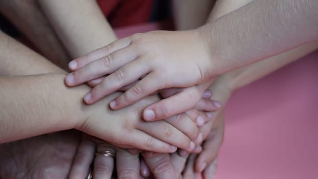 A friendly family will join hands on a pink background
