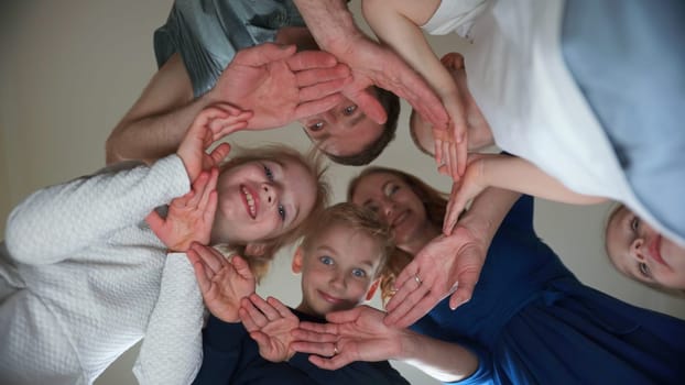 A friendly family makes a circle out of their hands