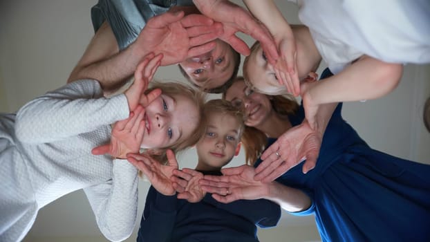 A friendly family makes a circle out of their hands
