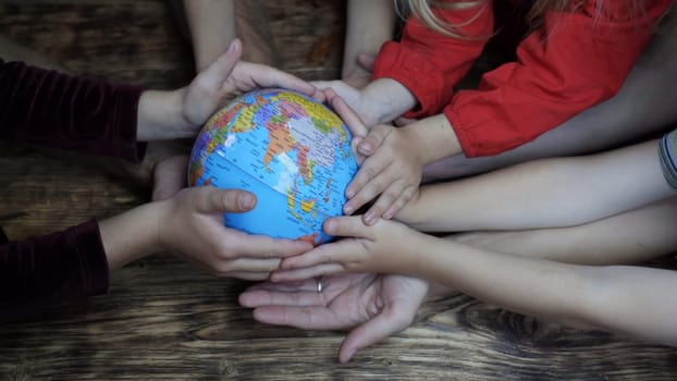 A friendly family hold the globe in their hands. The concept of saving the world
