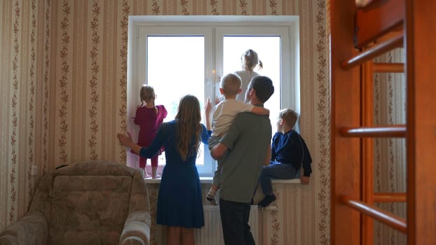 Large and friendly family at the window during quarantine
