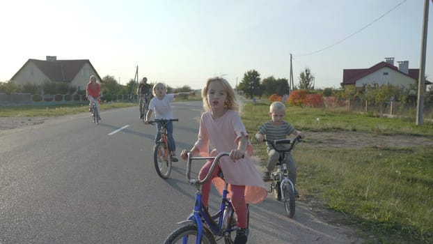 A large family goes on a bike ride in the evening