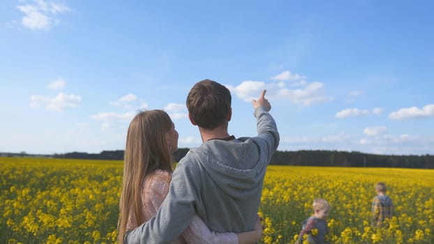 Happy family with kids in a rapeseed field