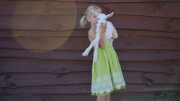 6 year old girl holding a small goat in her arms