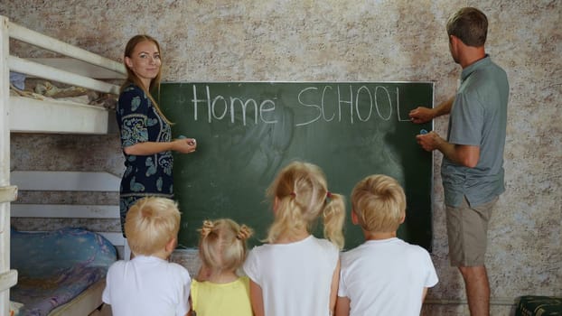 Home school concept. Parents write Home School on the blackboard