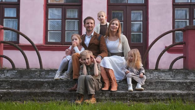 Portrait of a lot of children s family on the background of the old house