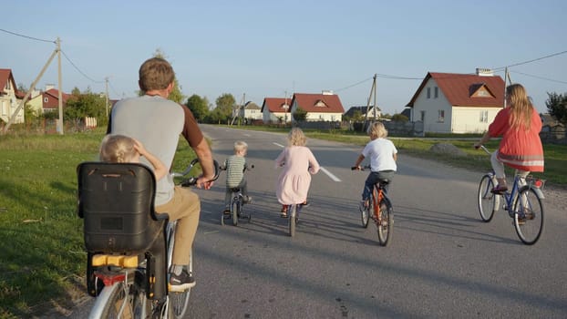 A large family goes on a bike ride in the evening