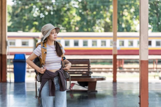 Woman traveler tourist with backpack at train station. Active and travel lifestyle concept.