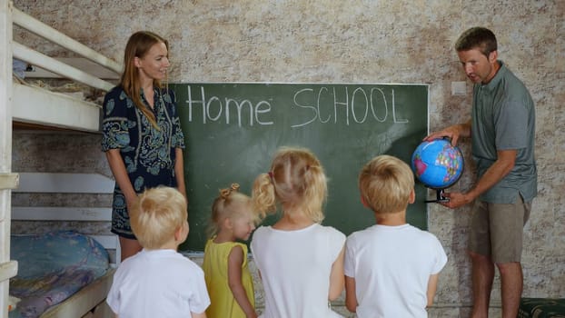 Home school concept. Parents teach their children with a globe in their hands