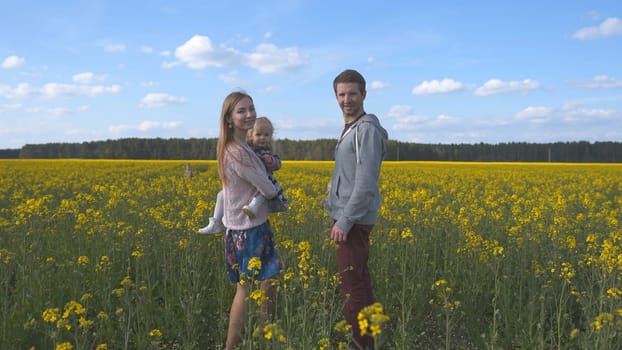 Young family with a daughter in a rapeseed field