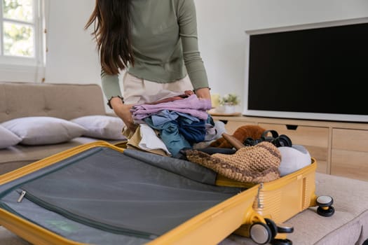 Woman packing a suitcase for a new travel trip. bag and luggage for journey.