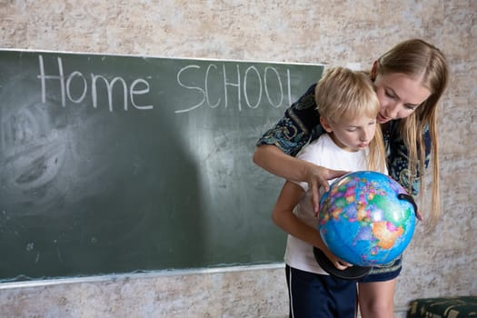 Mother is studying a world map on a globe with her son