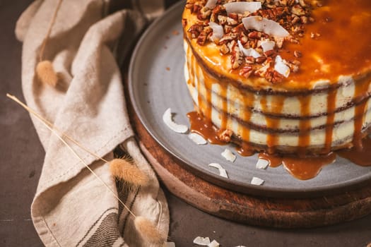 Delicious caramel cake with small pieces of pecan nuts and coconut shavings.