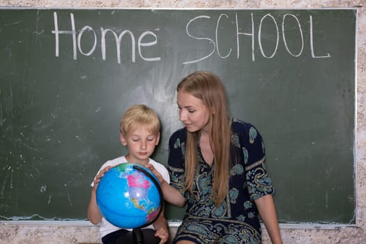 Mother is studying a world map on a globe with her son