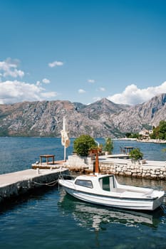 Small boat is moored at the stone pier of an ancient town. High quality photo