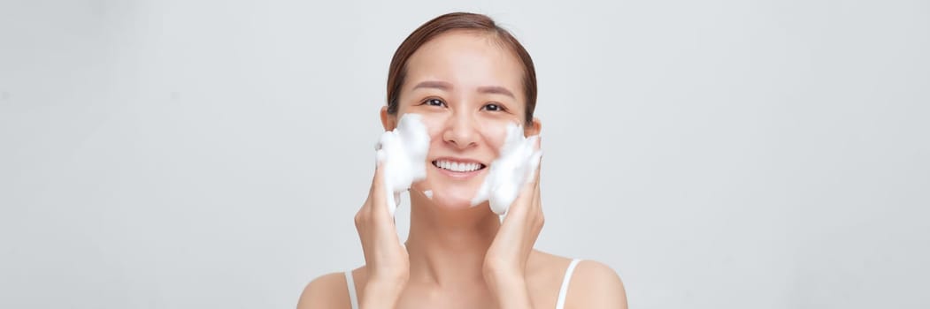 happy woman with foaming facial cleanser washing face isolated on white banner background.