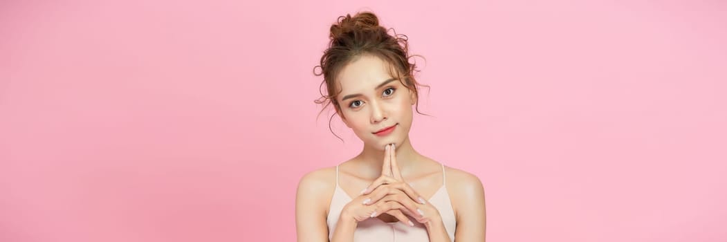 Portrait of attractive young woman over pink background