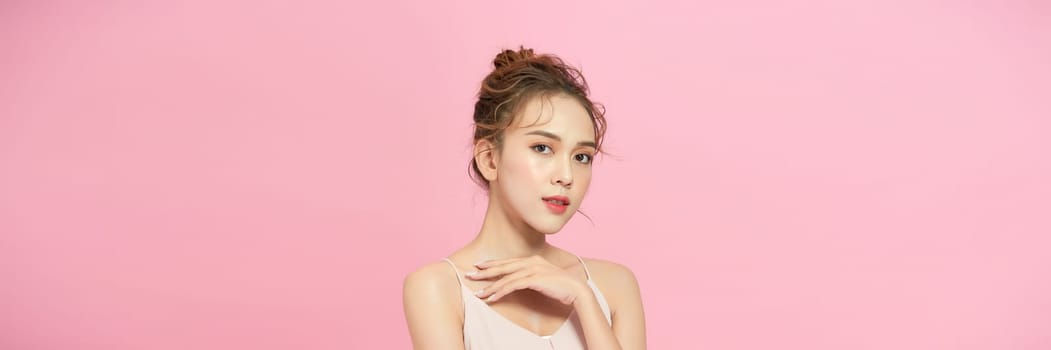 Portrait of attractive young woman over pink background