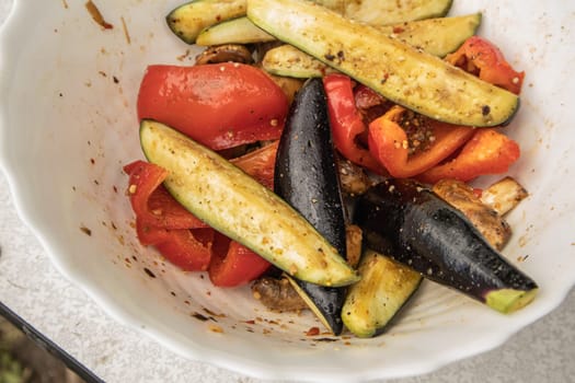 Grilled vegetables -bell peppers, zucchini, eggplant on a white plate, top view, close-up.