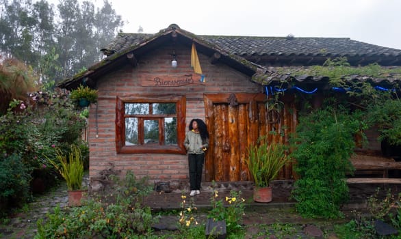 young afro woman outside her hut next to a gate surrounded by trees doing rural tourism in latin america. tourism day. High quality photo