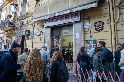 Napoli, Italy: 2023 November 18: People waiting on the street at La Antica Pizzeria Da Michele from 1870 where the authentic Margherita pizza is made in November 2023.