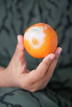 women holding a Moldy orange ,