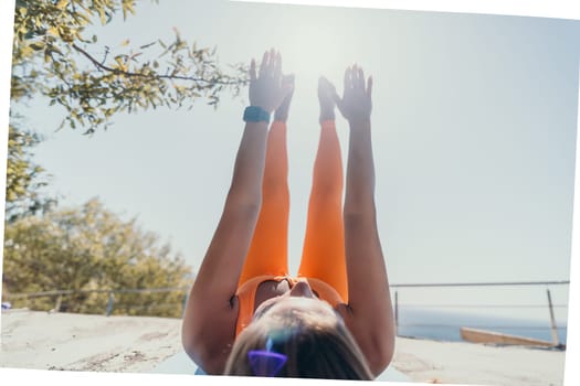 Fitness woman sea. Outdoor workout on yoga mat in park near to ocean beach. Female fitness pilates yoga routine concept. Healthy lifestyle. Happy fit woman exercising with rubber band in park.