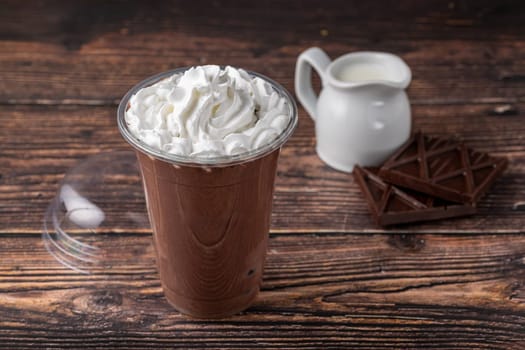 Chocolate milk in take away glass on wooden table