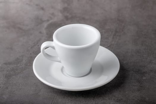 Empty white porcelain cup on gray stone background