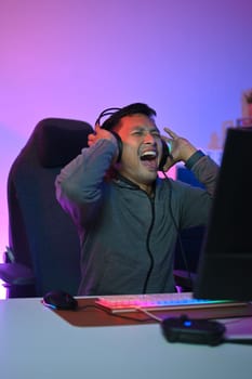 Excited male gamer screaming and celebrating his victory in online esport tournament