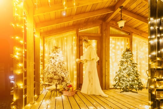 A woman in a white dress holding a gift box.