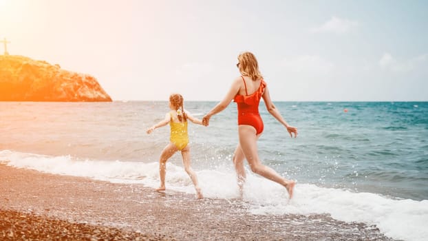 Happy loving family mother and daughter having fun together on the beach. Mum playing with her kid in holiday vacation next to the ocean - Family lifestyle and love concept.