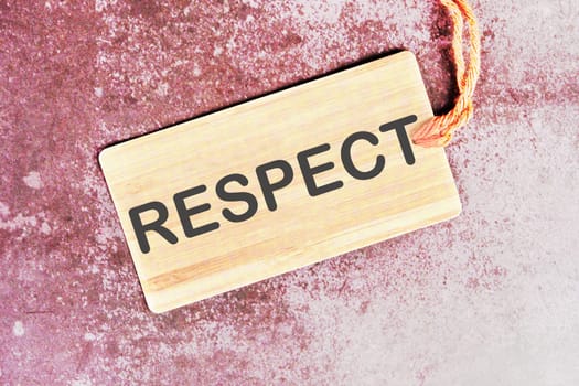 respect word written on a card with a rope on an abstract background
