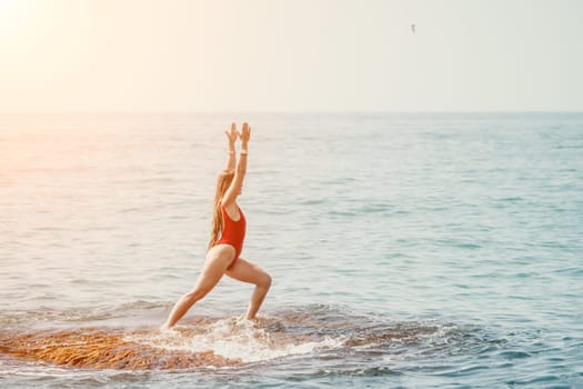 Woman sea yoga. Back view of free calm happy satisfied woman with long hair standing on top rock with yoga position against of sky by the sea. Healthy lifestyle outdoors in nature, fitness concept.