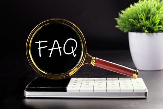 FAQ text seen with a magnifying glass on a black background