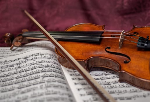 Beautiful violin and note sheets on purple background