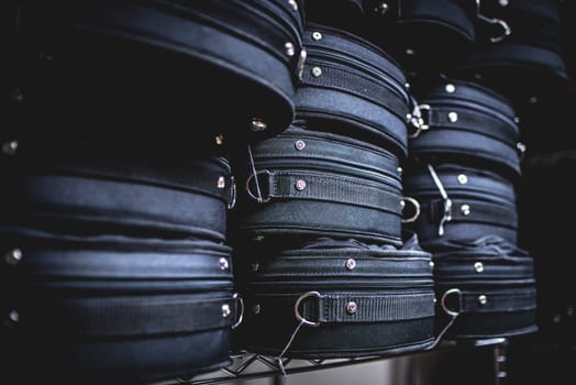 Many black violin cases stacked on top of each other