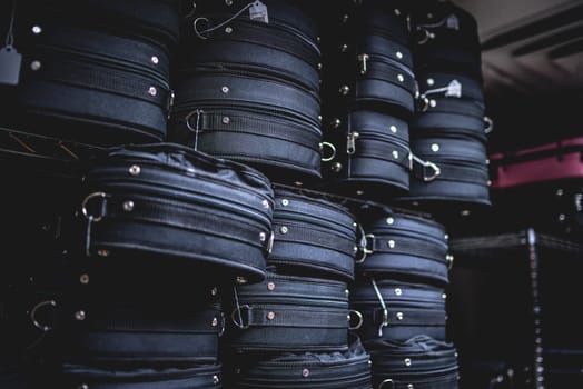 Many black violin cases stacked on top of each other