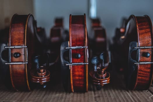 Wooden violins leaning sideways on a desk