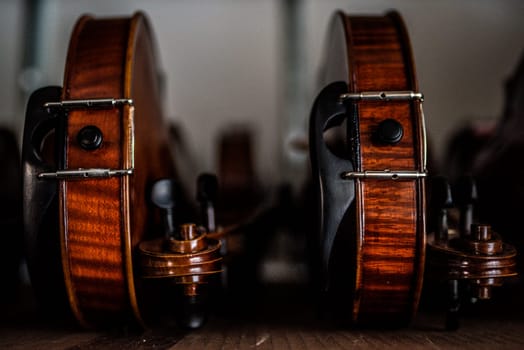 Wooden violins leaning sideways on a desk