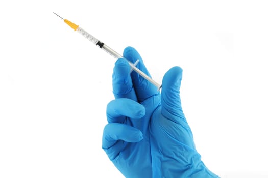 A vaccination syringe and hand in blue surgical glove