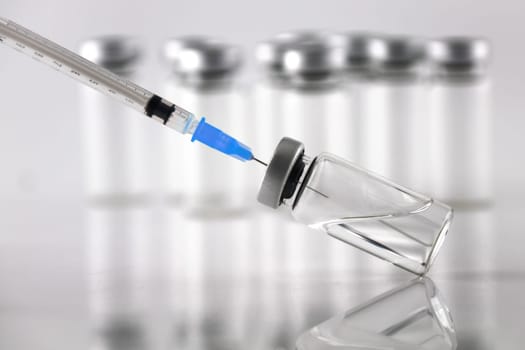A syringe and ampule bottles for vaccination on white background