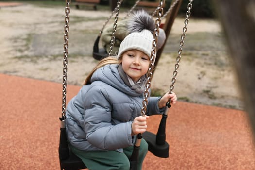 Girl of six years old riding on a swing