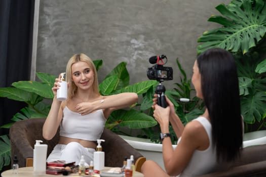 Two beautiful content creator making natural beauty and cosmetic tutorial on green plant garden video. Beauty blogger showing how to beauty care to social medial audience using selfie stick . Blithe