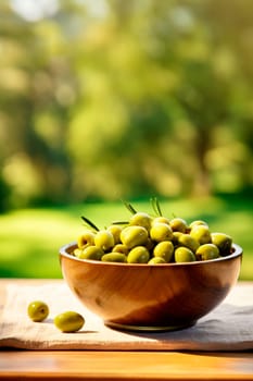 Olives in a bowl against the backdrop of the garden. Selective focus. Food.