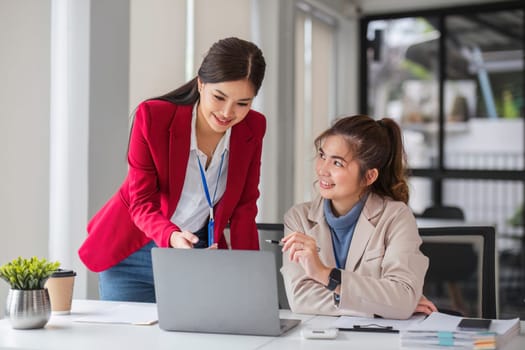 Two business women are discussing and exchanging knowledge on graphs and finance data..