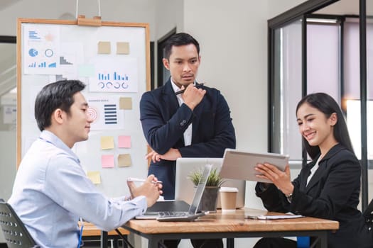 Professional businessman presenting to colleagues in conference room explaining growth chart.