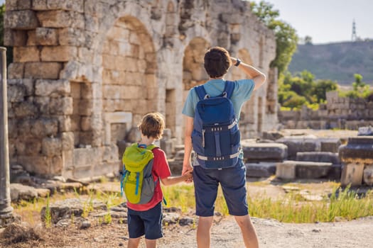 dad and son tourists at the ruins of ancient city of Perge near Antalya Turkey. Traveling with kids concept.