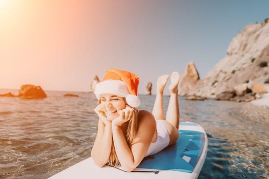 Close up shot of happy young caucasian woman looking at camera and smiling. Cute woman portrait in bikini posing on a volcanic rock high above the sea